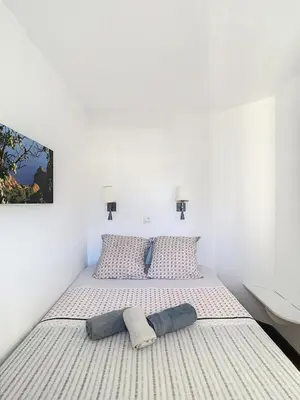a white bedroom with a large bed with two pillows at Le Francia - T2 30m2 - Piscine - Vue mer in Cannes