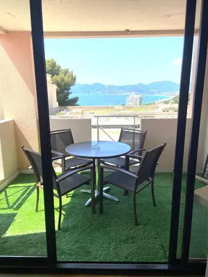 a table and chairs on a balcony with a view at Le Francia - T2 30m2 - Piscine - Vue mer in Cannes