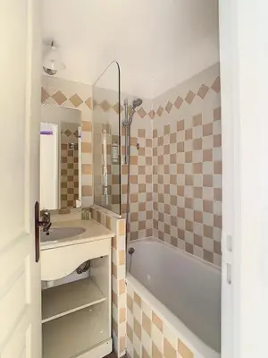 a bathroom with a tub and a sink and a mirror at Le Francia - T2 30m2 - Piscine - Vue mer in Cannes
