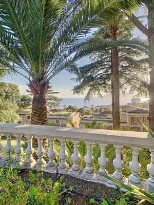a white fence with palm trees in the background at Le Francia - T2 30m2 - Piscine - Vue mer in Cannes