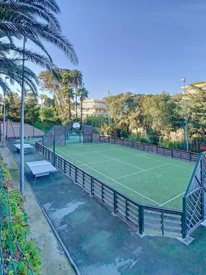a tennis court with two benches on it at Le Francia - T2 30m2 - Piscine - Vue mer in Cannes