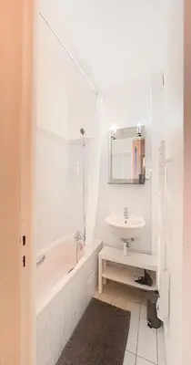 a white bathroom with a sink and a tub and a mirror at Le Palladium - Studio - 10mn Palais - Climatisé in Cannes