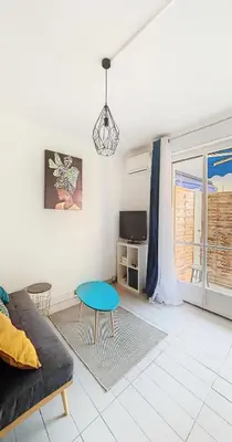 a living room with a couch and a table at Le Palladium - Studio - 10mn Palais - Climatisé in Cannes