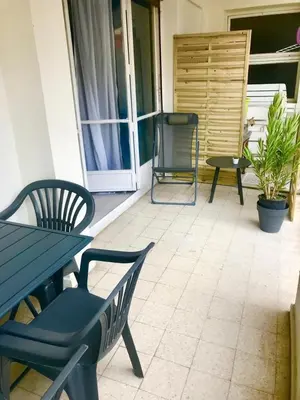 a patio with two chairs and a table and a table and chairs at Le Palladium - Studio - 10mn Palais - Climatisé in Cannes