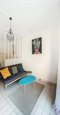 a living room with a couch and a table at Le Palladium - Studio - 10mn Palais - Climatisé in Cannes