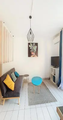 a living room with a couch and a blue table at Le Palladium - Studio - 10mn Palais - Climatisé in Cannes