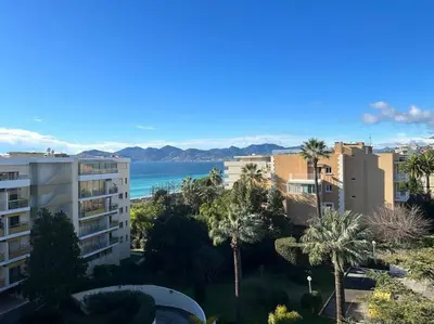 a view of a city with palm trees and the ocean at Appartement Pépite à Cannes in Cannes
