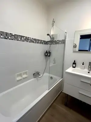 a white bathroom with a shower and a sink at Appartement Pépite à Cannes in Cannes