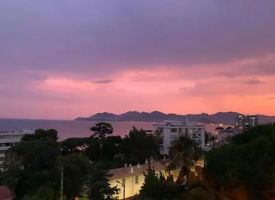 a view of the ocean and a city at sunset at Appartement Pépite à Cannes in Cannes