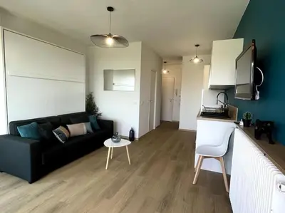 a living room with a black couch and a table at Appartement Pépite à Cannes in Cannes