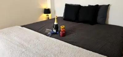 a bed with a bottle of wine and other toys on it at Cannes Beach Access, Private Room in Shared 3-Bedroom Apartment, Private Bathroom, Living Room with Sea View Suite Parentale salle de bain privée accès plages & vue mer du salon dans appartement partagé chez l'habitant in Cannes