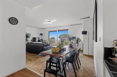 a kitchen and living room with a table and chairs at Cannes Beach Access, Private Room in Shared 3-Bedroom Apartment, Private Bathroom, Living Room with Sea View Suite Parentale salle de bain privée accès plages & vue mer du salon dans appartement partagé chez l'habitant in Cannes