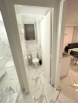 a bathroom with a toilet and a television on the wall at Evasion Cannoise in Cannes