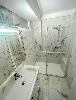 a white bathroom with a shower and a sink at Evasion Cannoise in Cannes