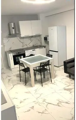 a kitchen with a table and some chairs and a refrigerator at Evasion Cannoise in Cannes