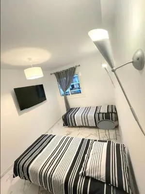 a bedroom with two beds and a lamp and a tv at Evasion Cannoise in Cannes