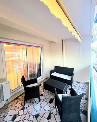 a living room with chairs and a table and a window at Evasion Cannoise in Cannes
