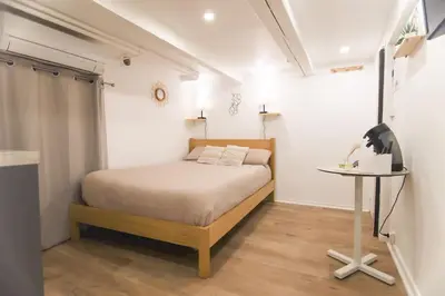 a small bedroom with a bed and a table at Studio palais des festivals Croisette in Cannes