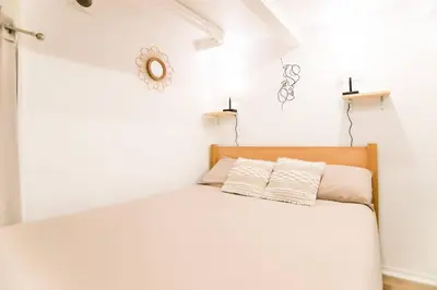 a white bedroom with a bed with two pillows at Studio palais des festivals Croisette in Cannes