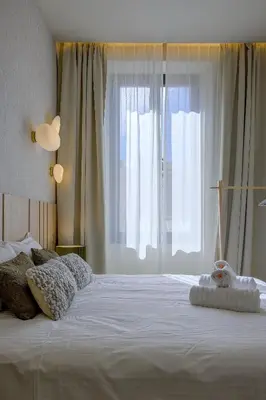 a bedroom with a large white bed with a large window at Jessicannes - ALBA - Plage et Palais des Festival à pied in Cannes