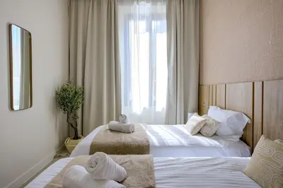 two beds in a hotel room with towels on them at Jessicannes - ALBA - Plage et Palais des Festival à pied in Cannes