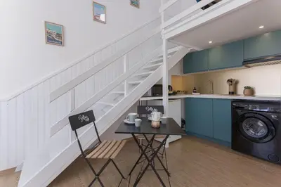 a room with a table and a staircase in a kitchen at Studio André - Palais & plage, clim in Cannes