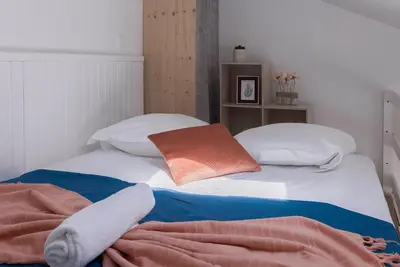 a bed with white pillows and an orange and blue blanket at Studio André - Palais & plage, clim in Cannes