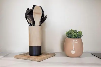 a wooden knife block next to a vase with scissors at Studio André - Palais & plage, clim in Cannes