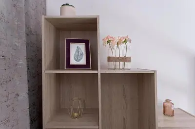 a wooden book shelf with vases and a picture at Studio André - Palais & plage, clim in Cannes