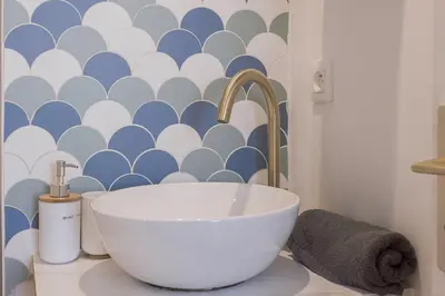 a bathroom with a sink and a blue and white wall at Studio André - Palais & plage, clim in Cannes