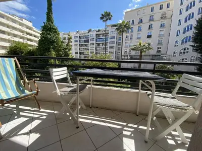 a table and chairs on a balcony with buildings at Cannes proche croisette - Studio balcon vue jardin in Cannes