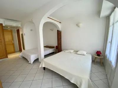 a bedroom with two beds and an arched doorway at Cannes proche croisette - Studio balcon vue jardin in Cannes
