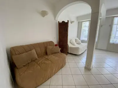 a living room with a couch and a chair at Cannes proche croisette - Studio balcon vue jardin in Cannes