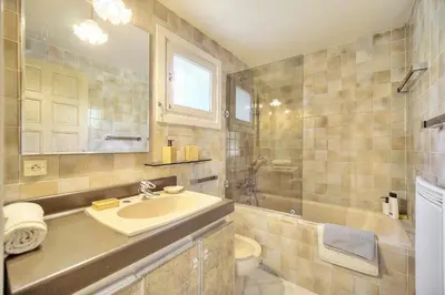 a bathroom with a sink and a toilet and a tub at Le Bel - Jardin - Parking - VCA in Cannes