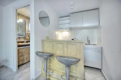 a kitchen with a counter and two stools in it at Le Bel - Jardin - Parking - VCA in Cannes