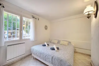 a bedroom with a bed and a window at Le Bel - Jardin - Parking - VCA in Cannes
