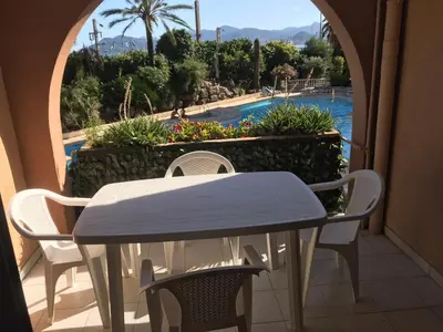 a table and chairs on a balcony with a view of a pool at Résidence Palme d'Azur Cannes La Bocca in Cannes