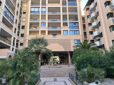 a building with palm trees in front of it at Résidence Palme d'Azur Cannes La Bocca in Cannes