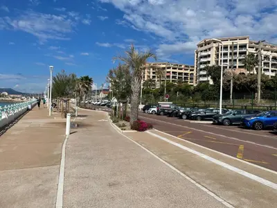 a sidewalk next to a parking lot with cars at Résidence Palme d'Azur Cannes La Bocca in Cannes