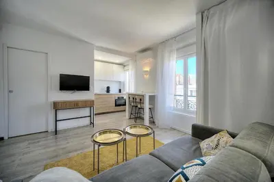 a living room with a couch and two tables at Immogroom - Luminious T2 - Center - AC - Wifi in Cannes