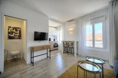 a living room with a couch and a staircase at Immogroom - Luminious T2 - Center - AC - Wifi in Cannes