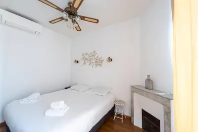 a bedroom with a bed and a picture on the wall at FRGK Suquet Olivier Historic 2-3 BR Charm UltraFast WiFi in Cannes