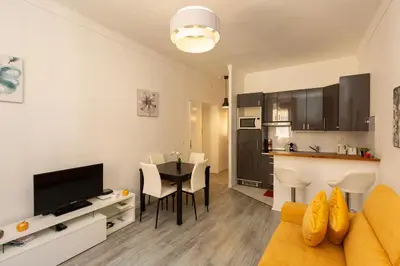 a living room with a couch and a table and a kitchen at Elegant 2 rooms in the heart of Cannes in Cannes