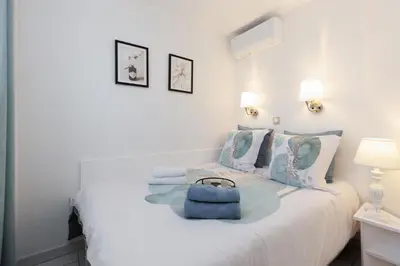 a bedroom with a bed with a blue bag on it at Holiday Paradise in Cannes
