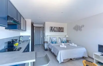 a kitchen and a bedroom with a bed in a room at Le Mimosas - Studio Cannes centre - Vue mer Terrasse WIFI climatisation in Cannes