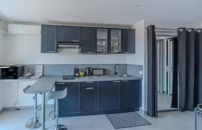a kitchen with blue cabinets and a counter top at Le Mimosas - Studio Cannes centre - Vue mer Terrasse WIFI climatisation in Cannes
