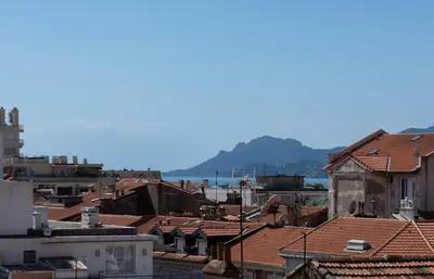 a view of roofs of buildings and the ocean at Le Mimosas - Studio Cannes centre - Vue mer Terrasse WIFI climatisation in Cannes