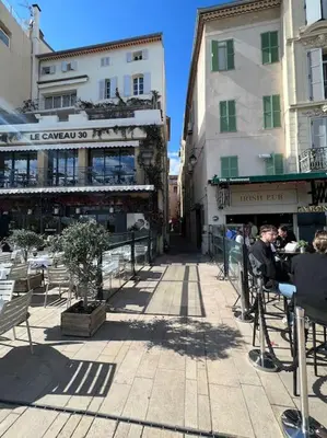 a group of people sitting at a table in a street at Appartement cannes centre à 3 minutes du palais des festivals in Cannes