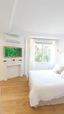 a white bedroom with a large bed and a window at La Dolce Vita de Cannes: Luxury city center apartement, beautiful View in Cannes
