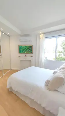 a white bedroom with a large white bed and a window at La Dolce Vita de Cannes: Luxury city center apartement, beautiful View in Cannes